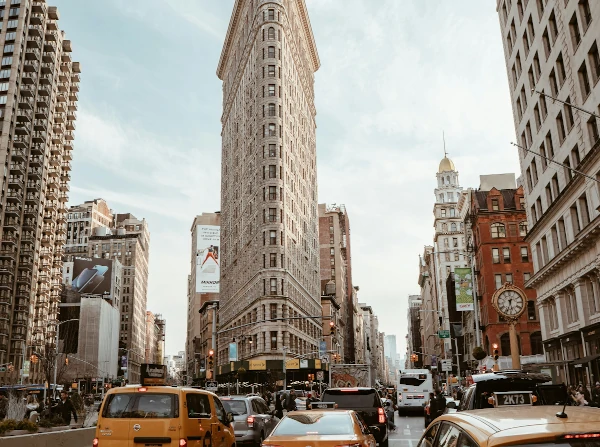 Flatiron Building, NYC: Fifth Avenue & Broadway intersection, with yellow taxis.