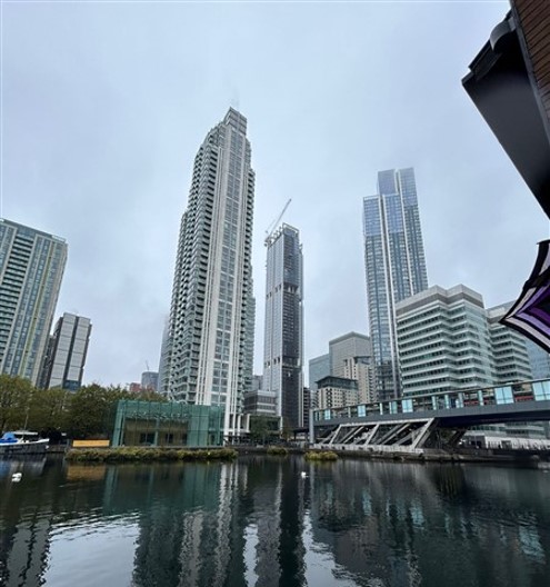 View of the Isle of Dogs in London with the Thames River and modern skyscrapers.