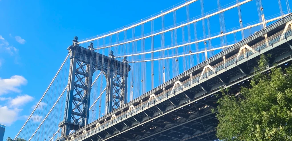 Image of the Brooklyn Bridge from an underside perspective, showcasing its iconic structure.