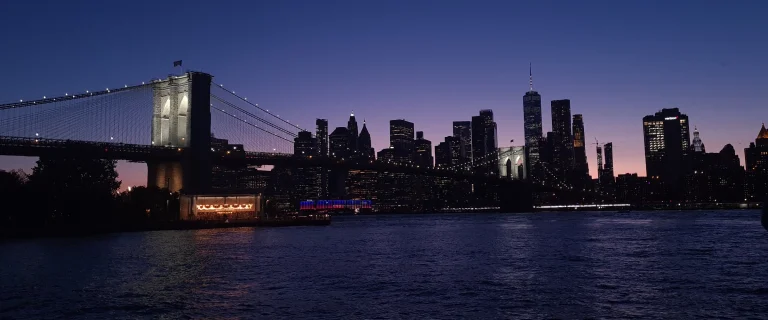 View of Brooklyn Bridge and Manhattan skyline from Pebble Beach at night
