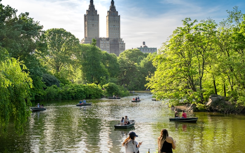 Barcas de remo navegando en el lago de Central Park con adolescentes remando en familia