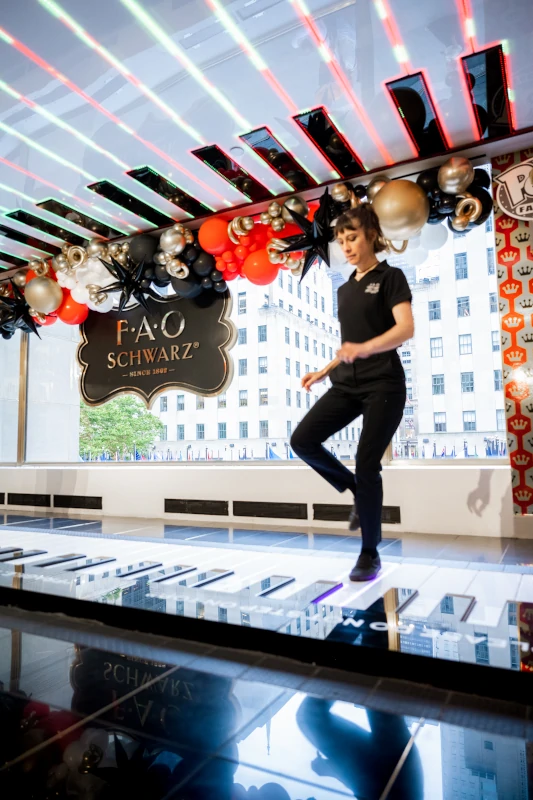 Woman playing on the giant piano at FAO Schwarz in New York City