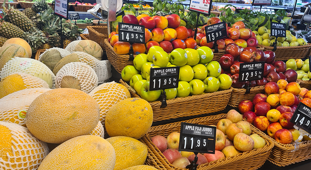 Sección de frutería del Almaya Supermarket en Dubai Marina con manzanas, melones y frutas frescas