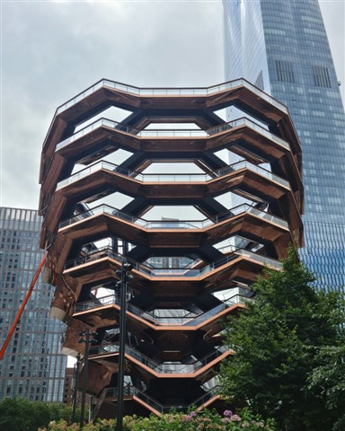 Imagen de Hudson Yards en Nueva York, mostrando el Vessel, una estructura icónica de forma espiral con visitantes alrededor.