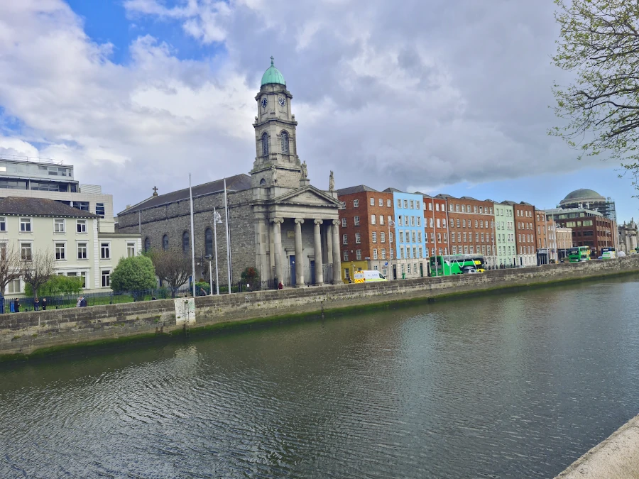 Vista de la Iglesia de Saint Paul's en Dublín desde el otro lado del río, con Four Courts al fondo