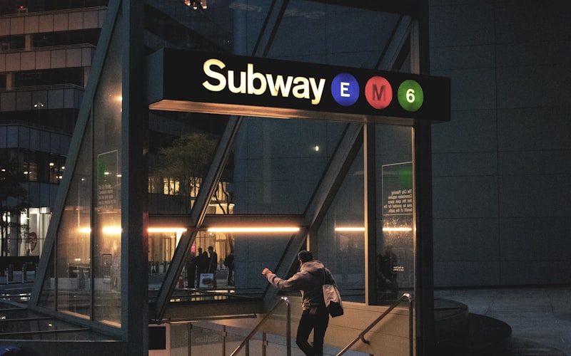 Letrero rojo de acceso al subway de Nueva York, cómo identificar las entradas al metro para familias
