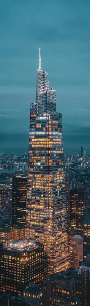 Night view of the illuminated Summit One Vanderbilt, a striking skyscraper in New York City, captured from an impressive perspective.