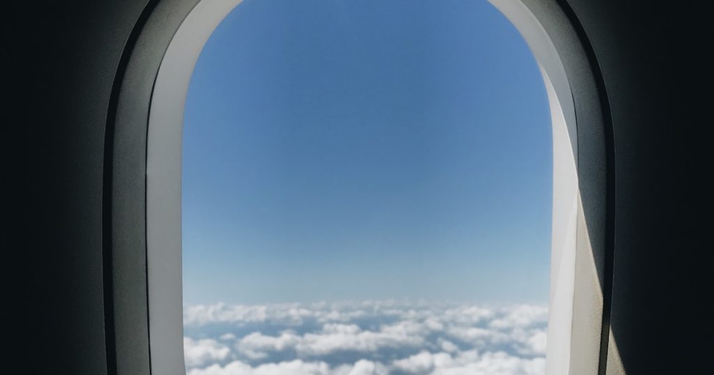 Vista desde la ventana del avión con ala y nubes, el vuelo Madrid Londres familia comienza así