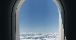 Vista desde la ventana del avión con ala y nubes, el vuelo Madrid Londres familia comienza así