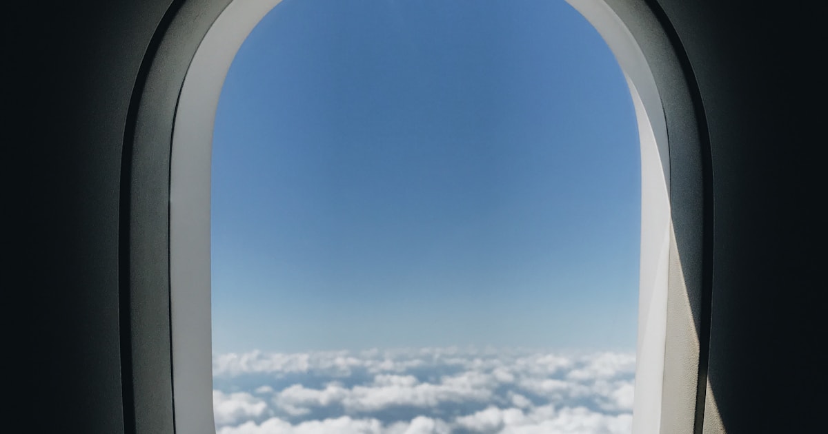 Vista desde la ventana del avión con ala y nubes, el vuelo Madrid Londres familia comienza así
